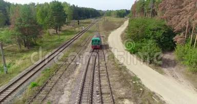 小火车头沿着森林里的铁路行驶，绿色火车头沿着森林路空中行驶