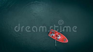 高空俯视图.. 湖上红船，顶景.. 两个年轻人在船上航行