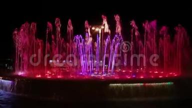 色彩斑斓的音乐喷泉在夜晚，闪烁着不同的色彩。
