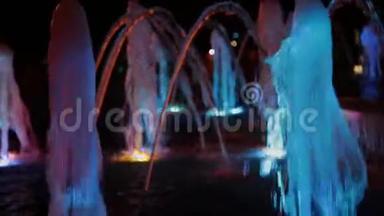 色彩斑斓的音乐喷泉在夜晚，闪烁着不同的色彩。