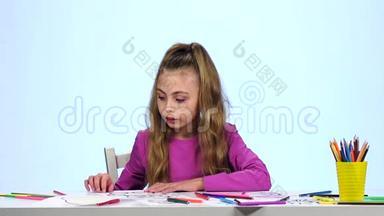 小女孩找到合适的铅笔并画画。 白色背景。 慢动作