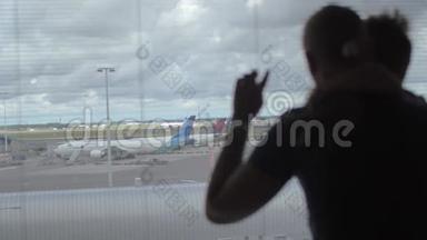 在荷兰阿姆斯特丹的<strong>飞机跑道</strong>上，母亲和儿子站在窗口观看的背面景色