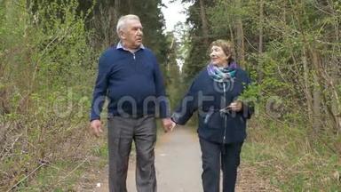 一对美丽的老年夫妇，在公园里散步，亲切地交谈。 好心情，积极生活.. 相爱，牵手。