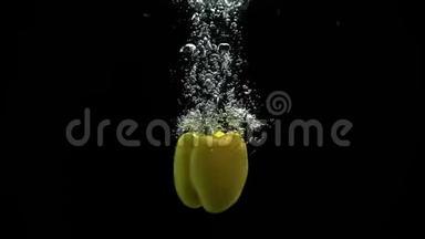 黄铃椒蔬菜落入水中，随着大量气泡旋转