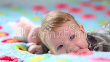 美丽的微笑<strong>宝宝</strong>：一个漂亮的小<strong>宝宝躺</strong>在床上，对着相机微笑，轻轻地聚焦着