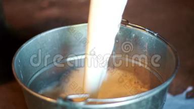 在<strong>奶牛</strong>场将新鲜牛奶倒入桶中。 乳制品