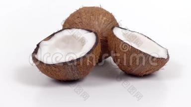 一整个椰子和<strong>两半</strong>，美味的果肉旋转在白色孤立的背景。 可循环无缝