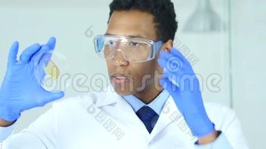 实验室观察玻璃、防护眼镜反应的科学家