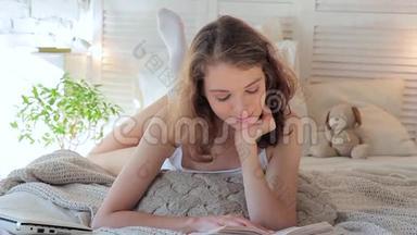 早上躺在床上微笑着看书的年轻女子