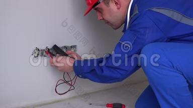白人电工在墙上插座上工作