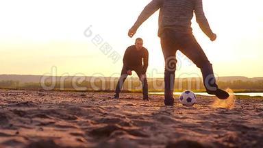 日落时在海滩上<strong>踢足球</strong>，体育<strong>学生</strong>在海滩上放松。