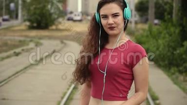 迷人的年轻女子戴着耳机听音乐<strong>播放器</strong>上的音乐