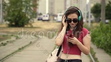 迷人的年轻女子戴着耳机听音乐播放器上的音乐