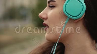 迷人的年轻女子戴着耳机听音乐播放器上的音乐