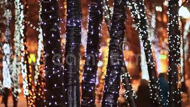 圣诞节。 在夜晚的城市<strong>街道</strong>上，一丛丛丛的树木在节日的发光<strong>照明</strong>中。 行走的路人.. 新年