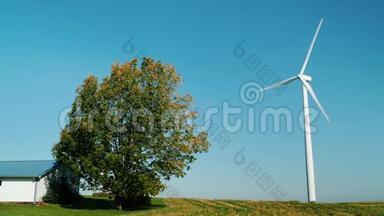 房屋或农场的独立供电.. 风力发电机在建筑物附近，一棵树正在附近生长