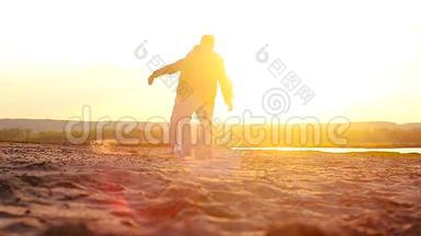 日落时在海滩上踢足球，体育学生在海滩上放松。