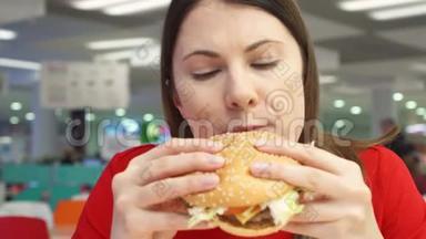 饥饿的女孩在食物场上吃汉堡包。 快餐店的女人咬芝士汉堡。