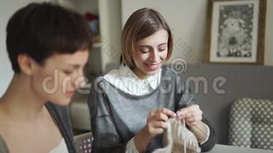两个年轻女子在<strong>纺织车间</strong>一起编织羊毛纱。 编织组