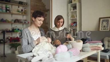 在缝纫车间的餐桌上工作的针织妇女。 女子编织组