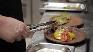 厨师躺在盘子里，蔬菜在现代化的大厨房烤架上煎