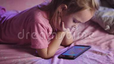 孩子躺在床上。 女孩准备睡觉。 在睡觉前，孩子看着动画片