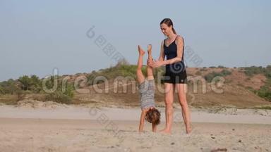 年轻的运动妈妈和小女儿在海滩上做体操。