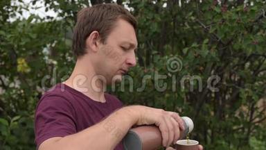 带热水瓶的人在户外喝茶