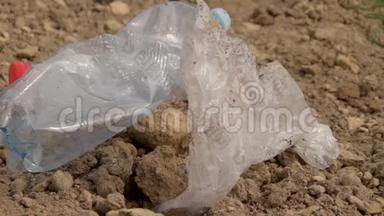 地面塑料的污染.. 塑料垃圾躺在地上。 环境保护。 塑料瓶和其他垃圾