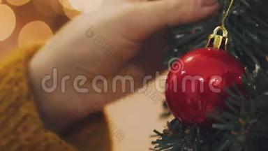 女人用圣诞<strong>彩灯装饰</strong>圣诞树的手。