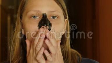 面部护理。 十几岁的女孩用泥面膜清洁她的鼻子<strong>毛孔</strong>。 4KUHD。