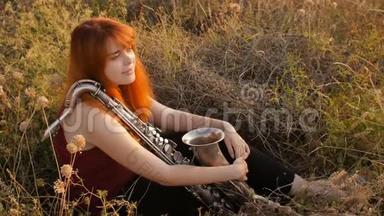夕阳西下的剪影年轻漂亮的红发女孩在玩萨克斯管自然，一个女人吹进<strong>烟斗</strong>，概念爱好，音乐
