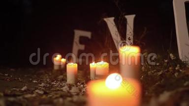 浪漫的蜡烛在夜间公园的路上燃烧，白色的字母在夜间公园的路上爱，特写