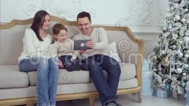 爸爸，妈妈和他们的小儿子<strong>一起玩</strong>，坐在沙发上的<strong>平板</strong>电脑<strong>玩</strong>得很开心