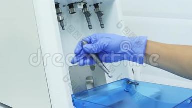 戴着医用手套的牙科医生的手，用手机清洁器