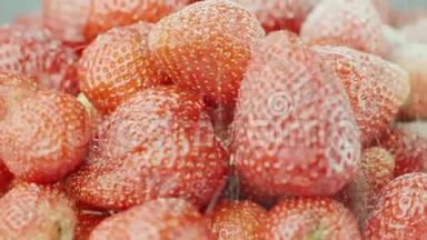 把红色多汁的草莓撒上糖。 糖粒落在草莓浆果上，慢动作视频
