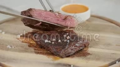 餐厅里的人拿着一把刀切了牛排，烤着大理石牛肉。 在木板上工作。 牛肉牛排烹饪
