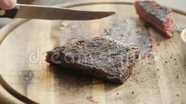 餐厅里的人拿着一把刀切了牛排，烤着大理石<strong>牛肉</strong>。 在木板上工作。 <strong>牛肉</strong>牛排烹饪