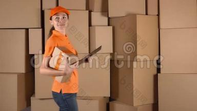 漂亮的女仓库工人在橙色制服搜索项目与棕色纸板箱背面。 4K视频