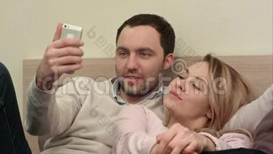 情侣们玩着玩着通过智能手机在床上自拍