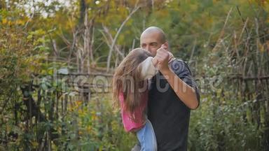 <strong>爸爸</strong>抱在怀里。 <strong>爸爸</strong>和女儿在秋天的公园里玩旋转和跳舞的乐趣。 慢动作