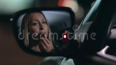 年轻女子在车里涂红唇膏