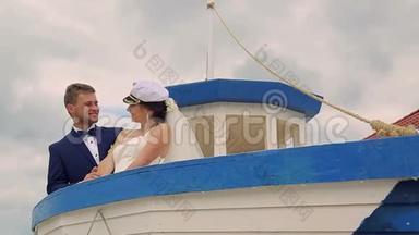 快乐的新娘和新郎在船上航行。 在年轻人的<strong>掌舵</strong>下