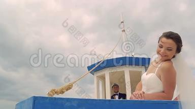 快乐的新娘和新郎在船上航行。 在年轻人的掌舵下