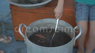 在河中捕获的活<strong>小龙虾</strong>是在露天的Arge铝锅里煮熟的。 女人把迪尔放进平底锅和盐水里。 <strong>小龙虾</strong>
