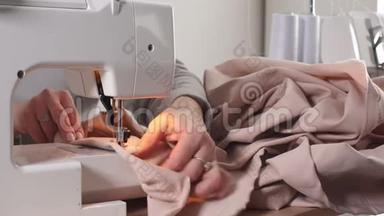 高级女裁缝正在一家<strong>服装厂</strong>的缝纫机上工作。