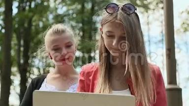 年轻<strong>漂亮</strong>女孩的脸<strong>大</strong>学女孩手里拿着笔记本电脑在<strong>绿</strong>色公园。 特写镜头。