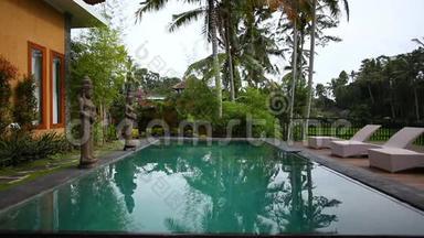 棕榈树背景下别墅里的游泳池和日光浴