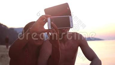热带海滩美丽的日落期间，几个最好的朋友用手机自拍。 慢动作。 高清高清