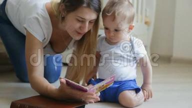 漂亮的年轻妈妈在客厅的地板上给她的小儿子读一本书